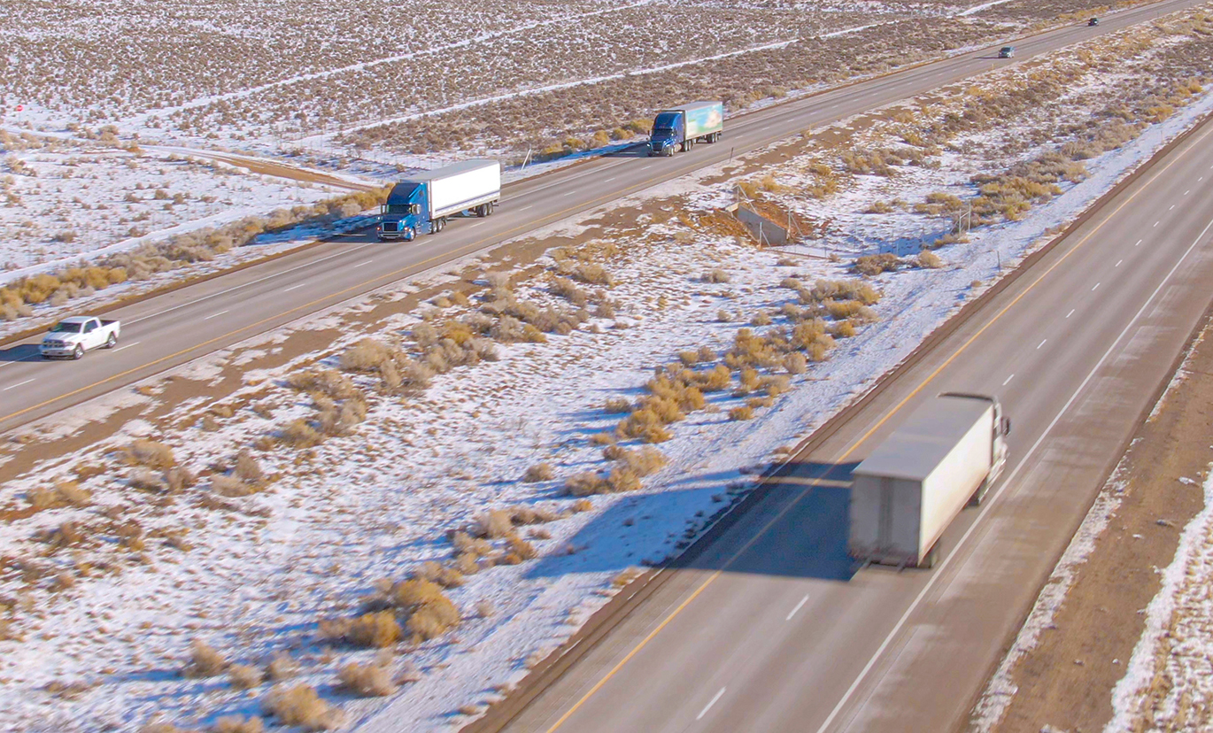 Camions semi-remorques circulant sur l'autoroute enneigée