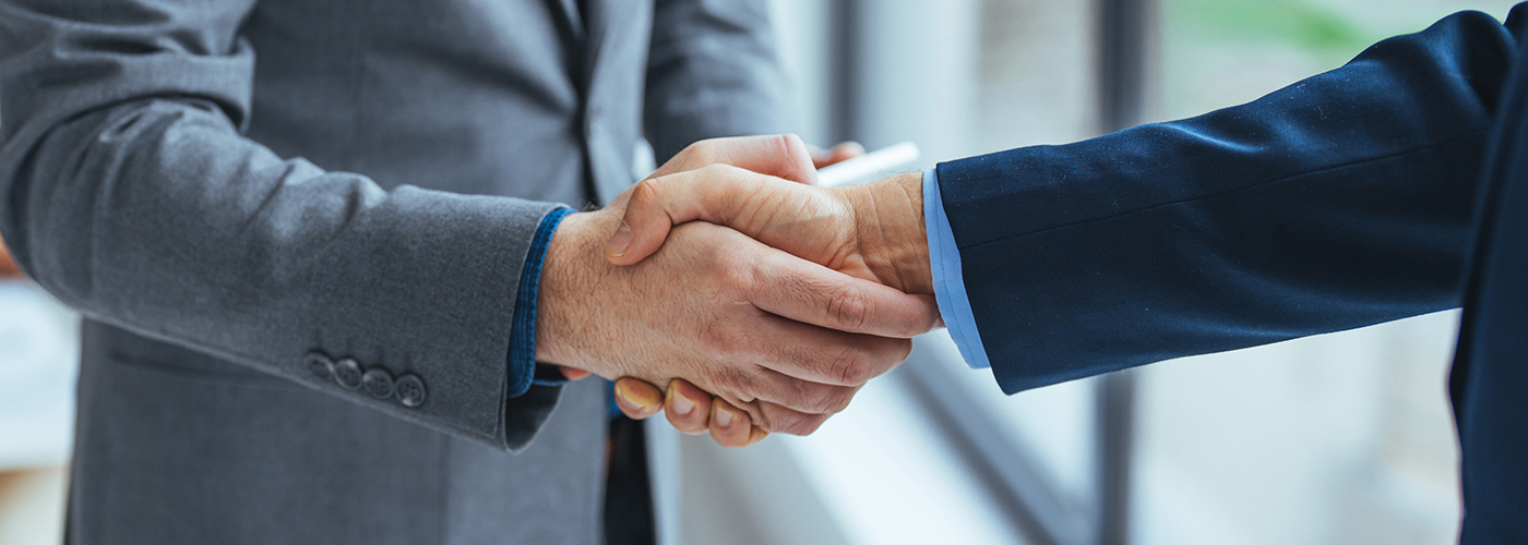 好交易。两位商务人士在工作场所握手的特写。商业、工作、成功理念。经理与新员工握手的照片。
